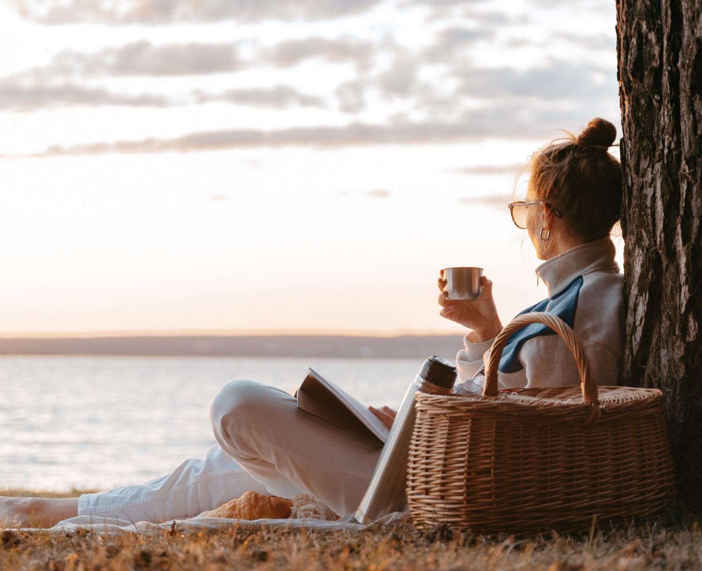 woman reflecting, sitting by water