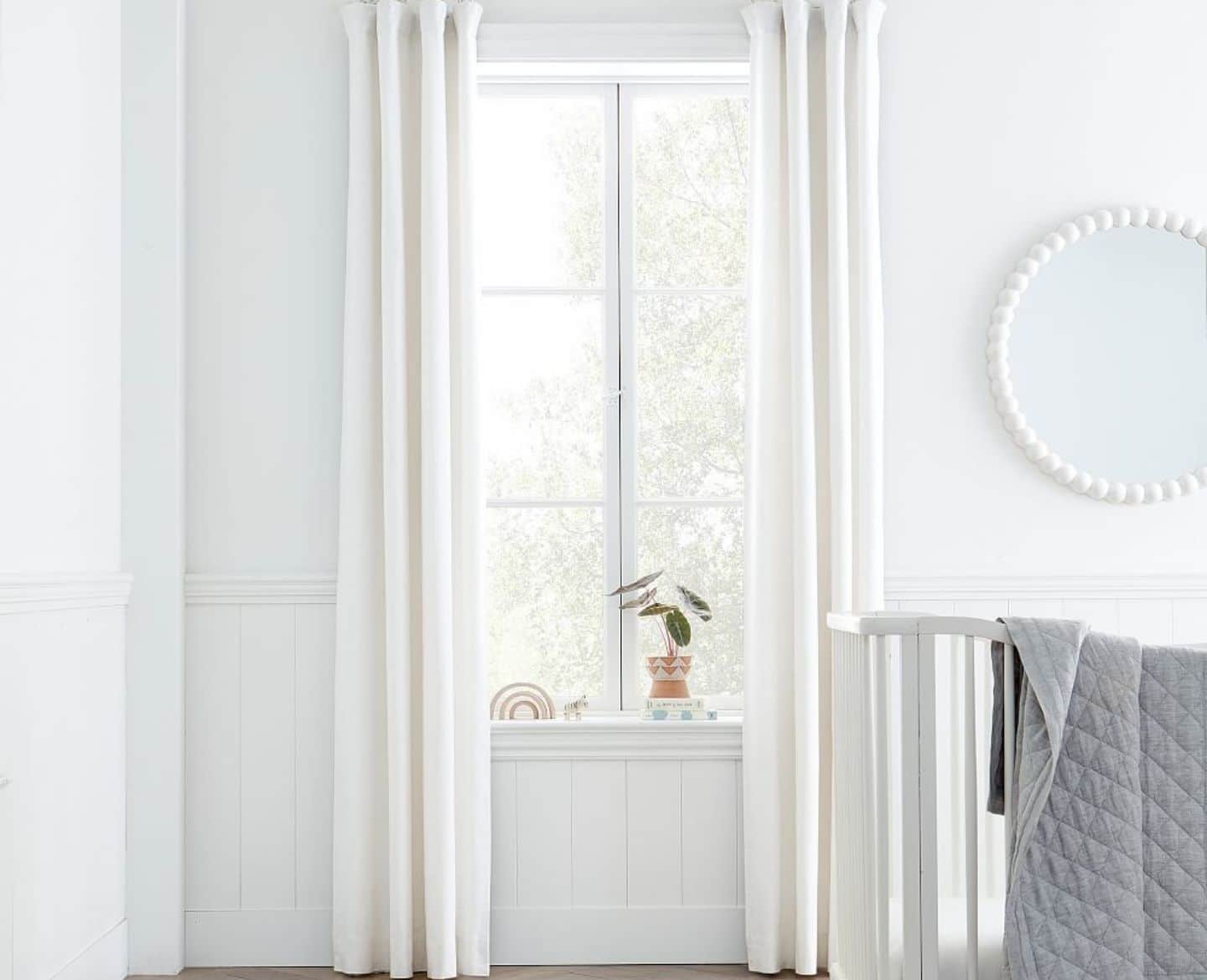 Nursery window with white curtains