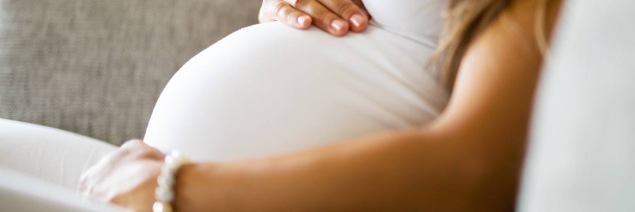 pregnant woman with hand over her belly