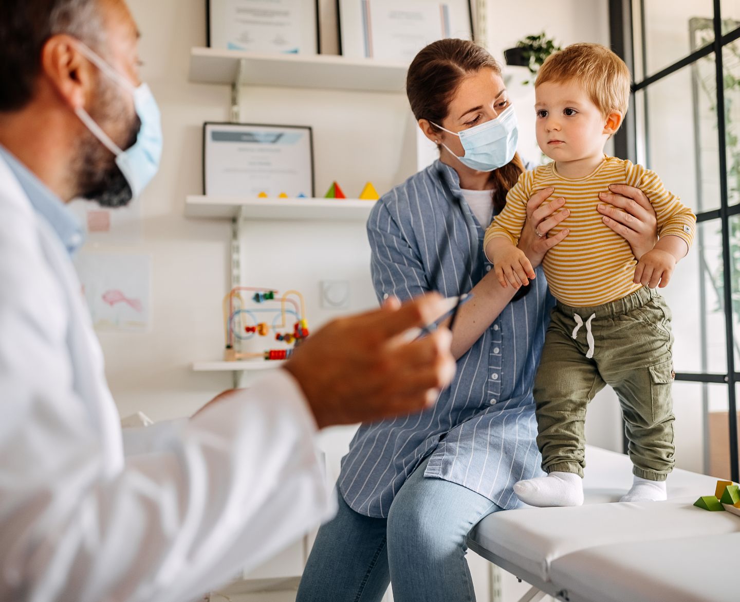 Mother and baby son at doctors office for vaccine Motherly