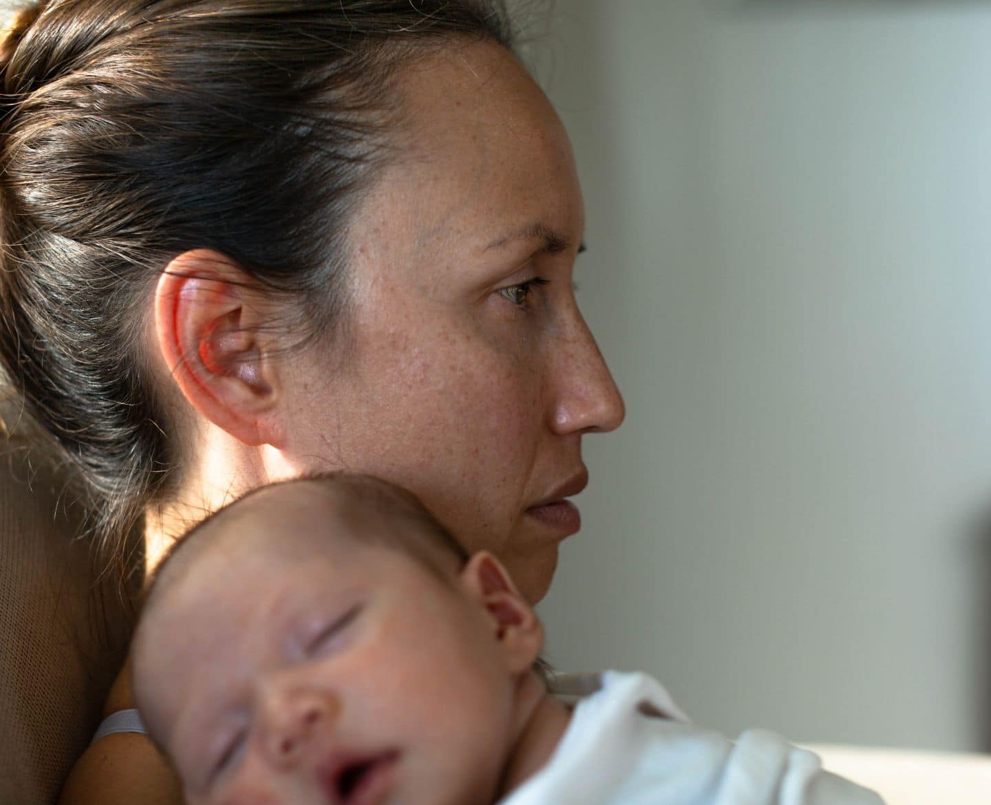 maternal mental health: mother holding sleeping baby at home