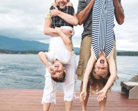 Parents Hanging Two Kids Upside Down On The Dock At The Lake Motherly