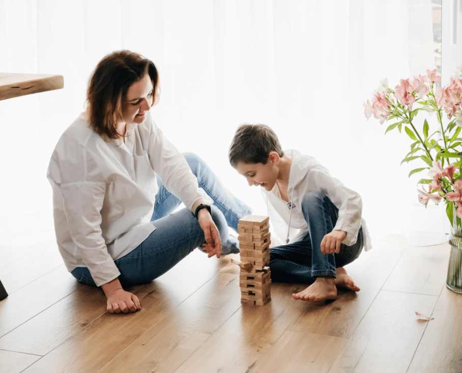 mom and child playing jenga on the floor