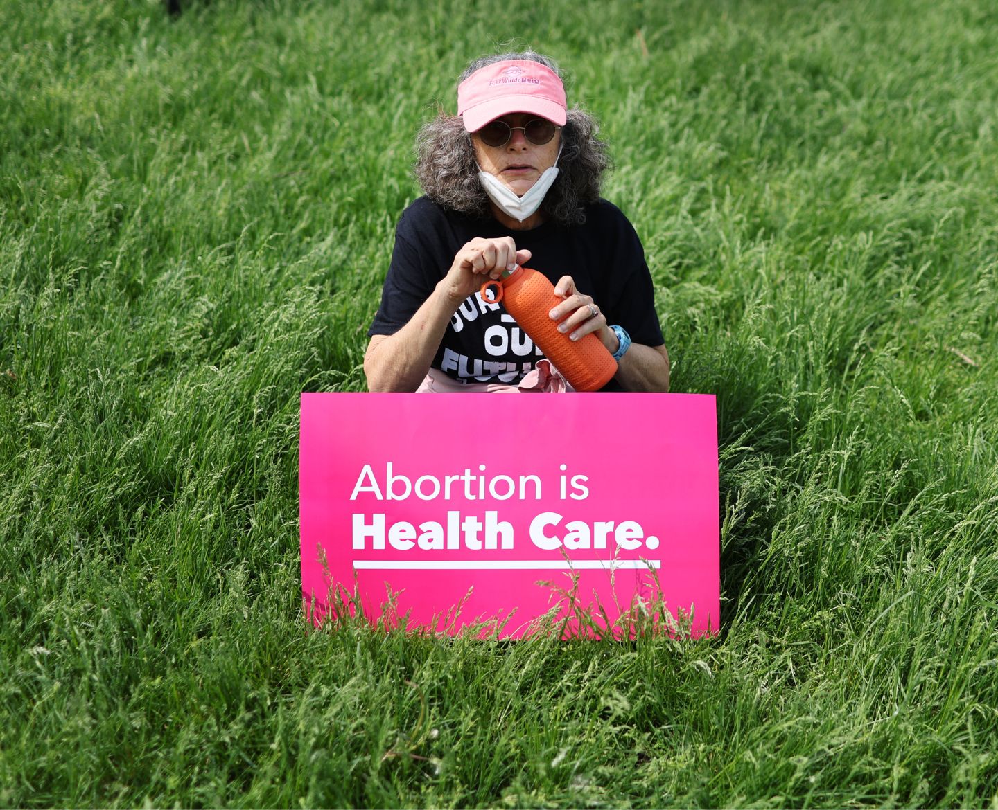 woman holding a sign that says 'abortion is health care' in abortion protest