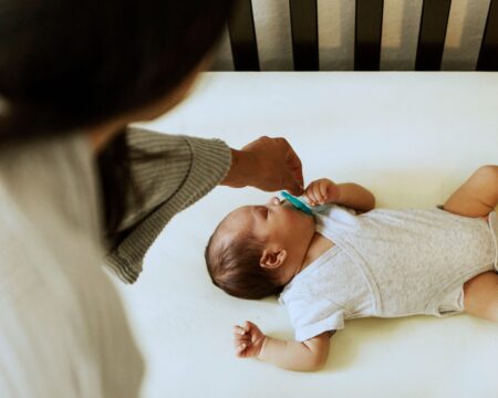 baby sleeping in crib mom offering pacifier1