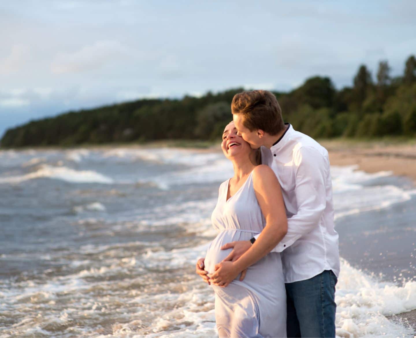 pregnant woman & partner on beach - babymoon destinations