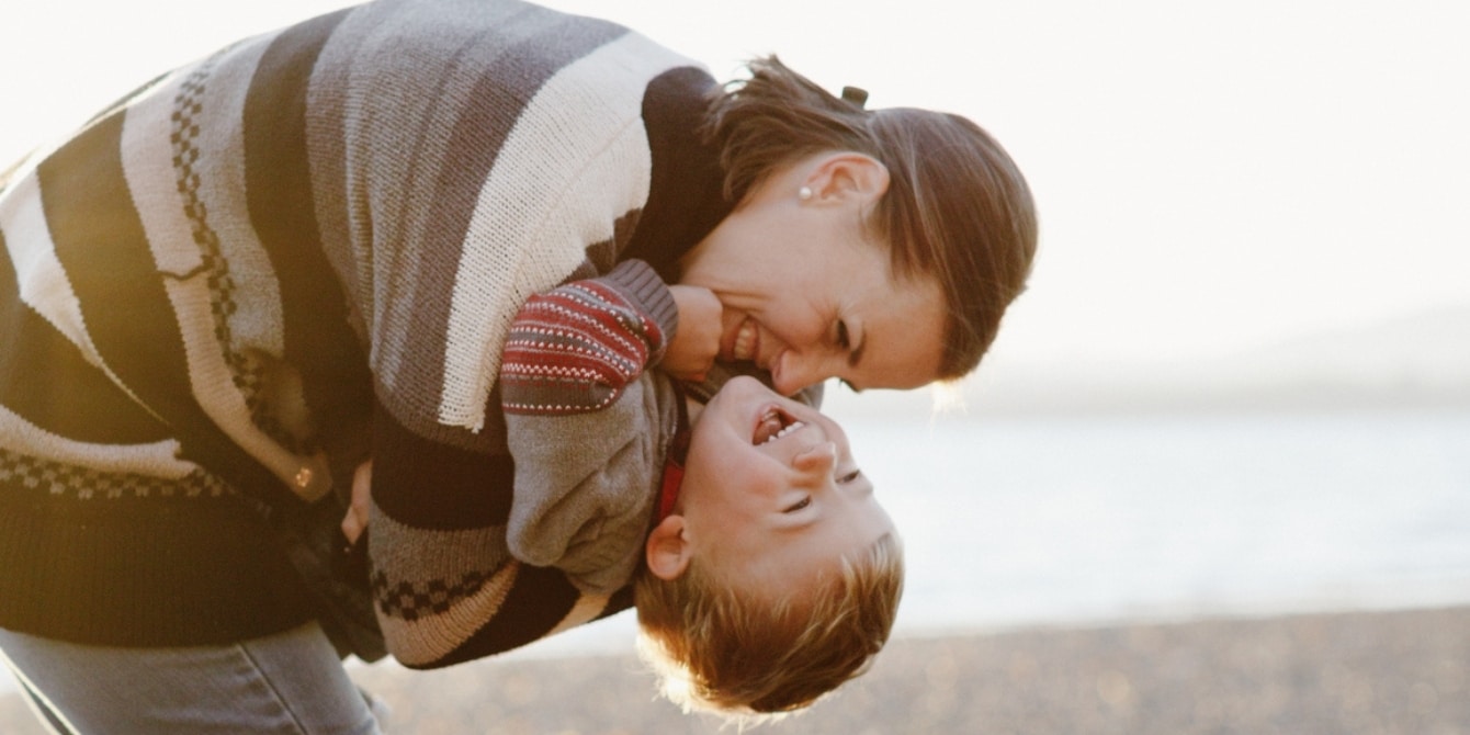 mom hugging child on the beach- single moms on father's day