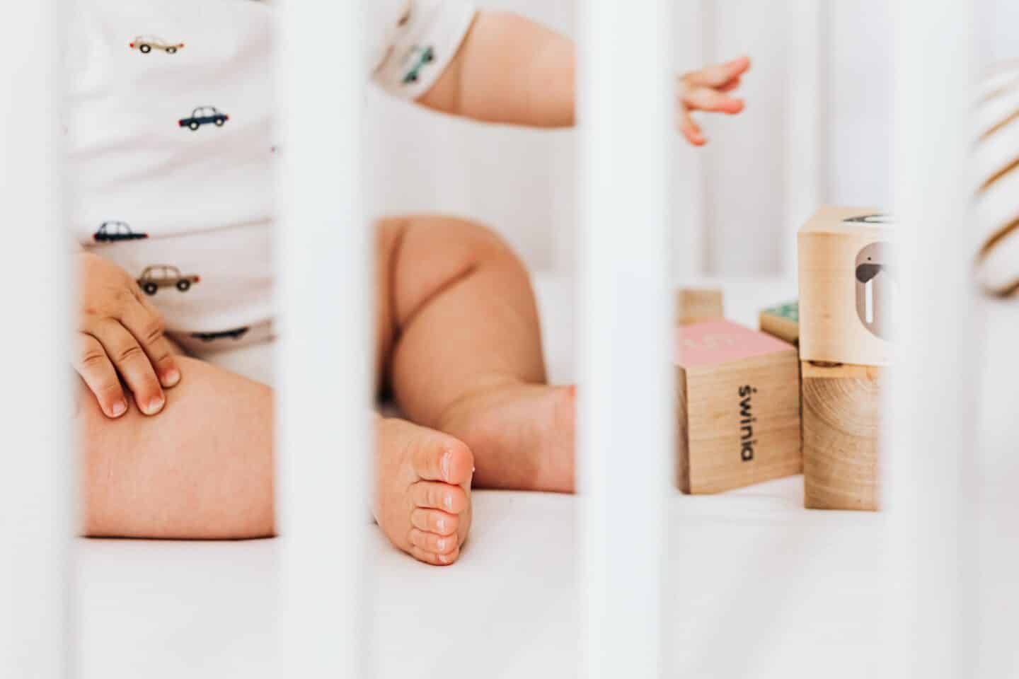 baby toes in a crib with blocks