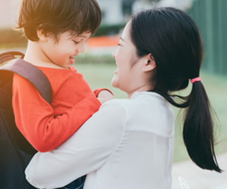 mom hugging son wearing backpack