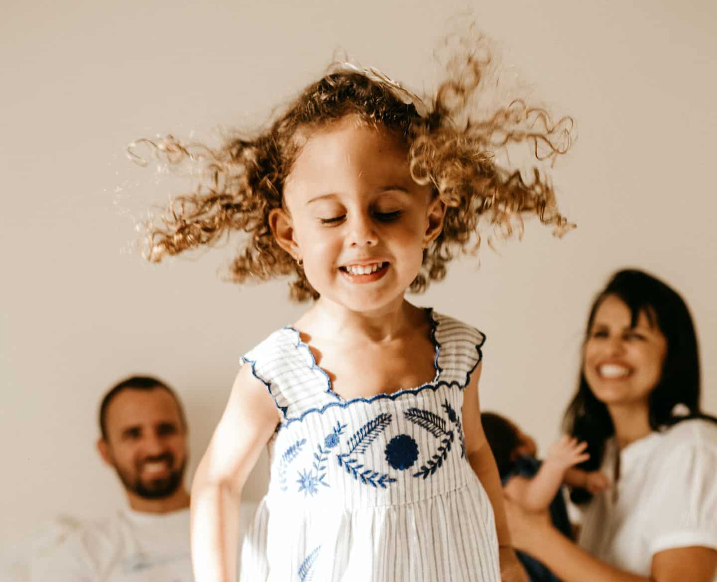 little girl jumping on the bed