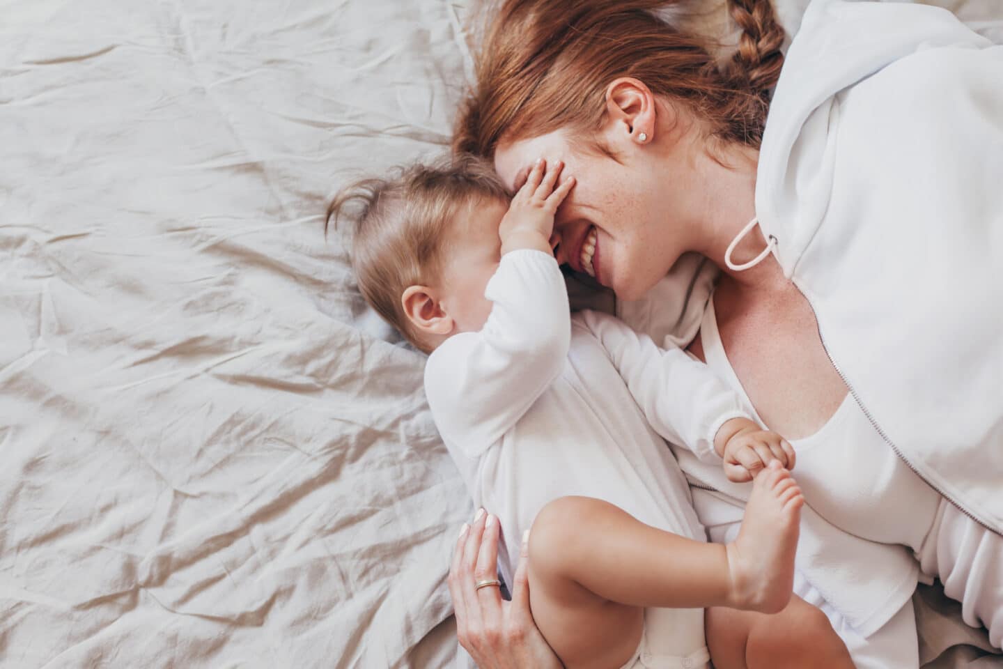 mom and baby playing on bed - bonding with your baby