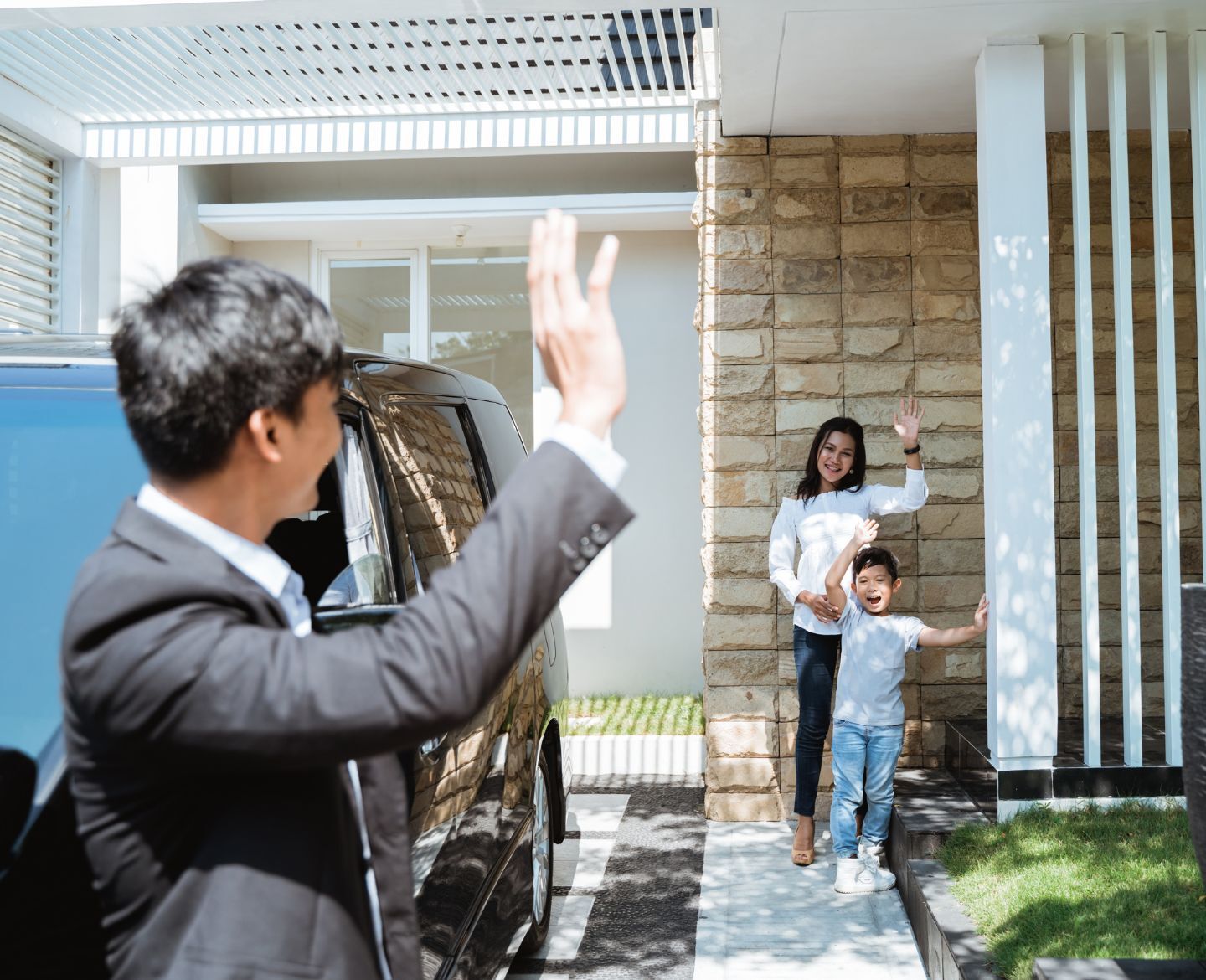 mom and son waving goodbye to dad