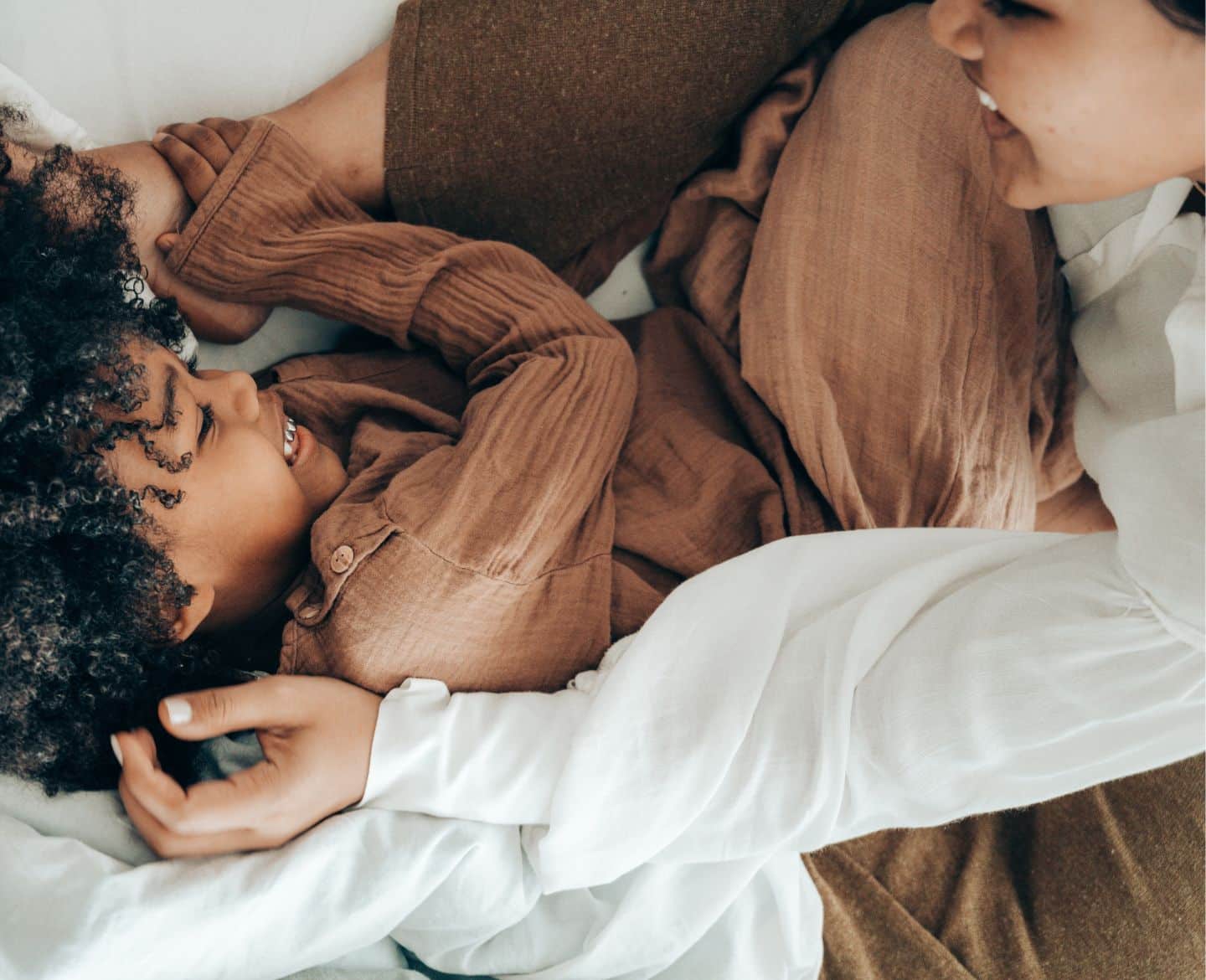 mom and son laughing on bed