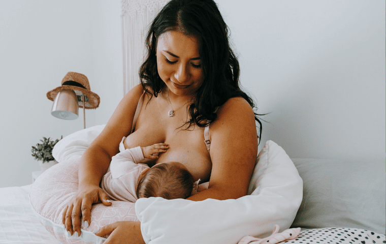 mom breastfeeding a baby using a boppy