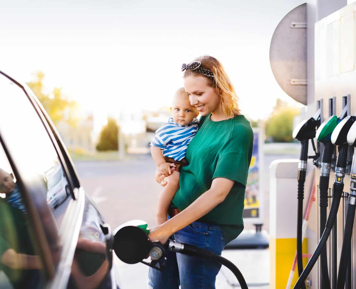 woman and baby pump gas - how to get better gas mileage