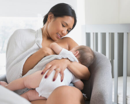 woman sitting in armchair breast feeding