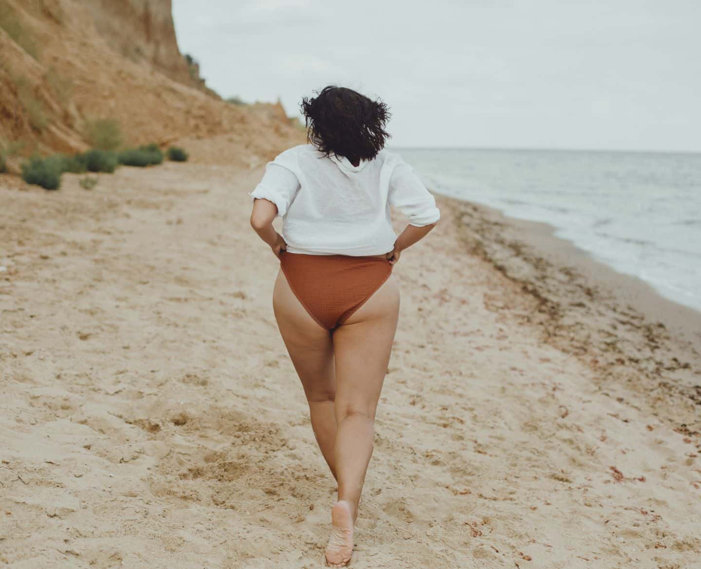 woman walking on beach in bikini