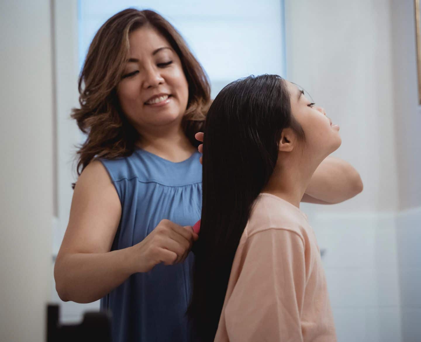 mother combing hair of her daughter- best detangler spray