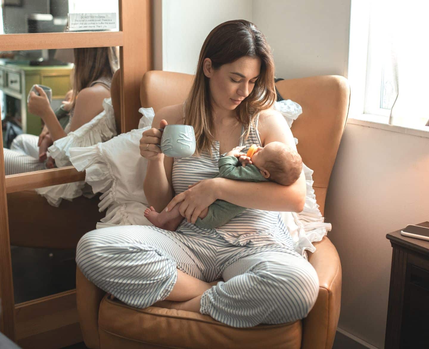 Mom drinking coffee holding baby - is coffee good for you