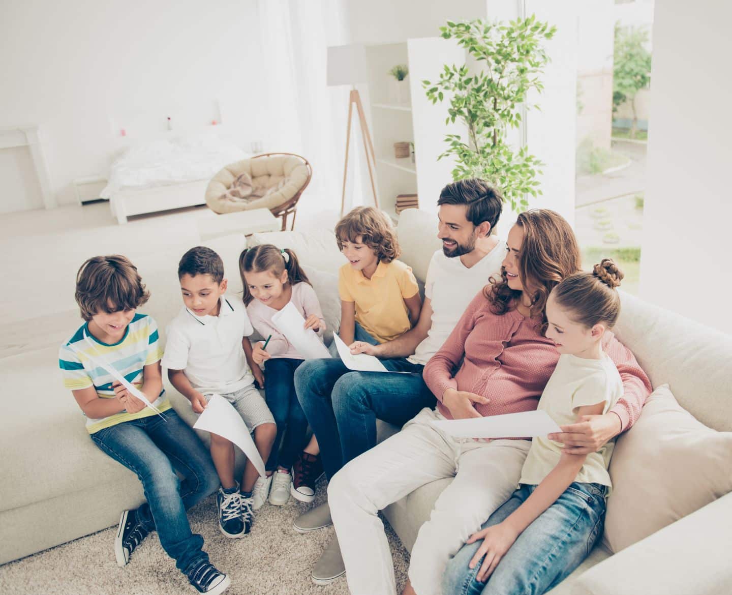 big family sitting on the couch together looking at a book