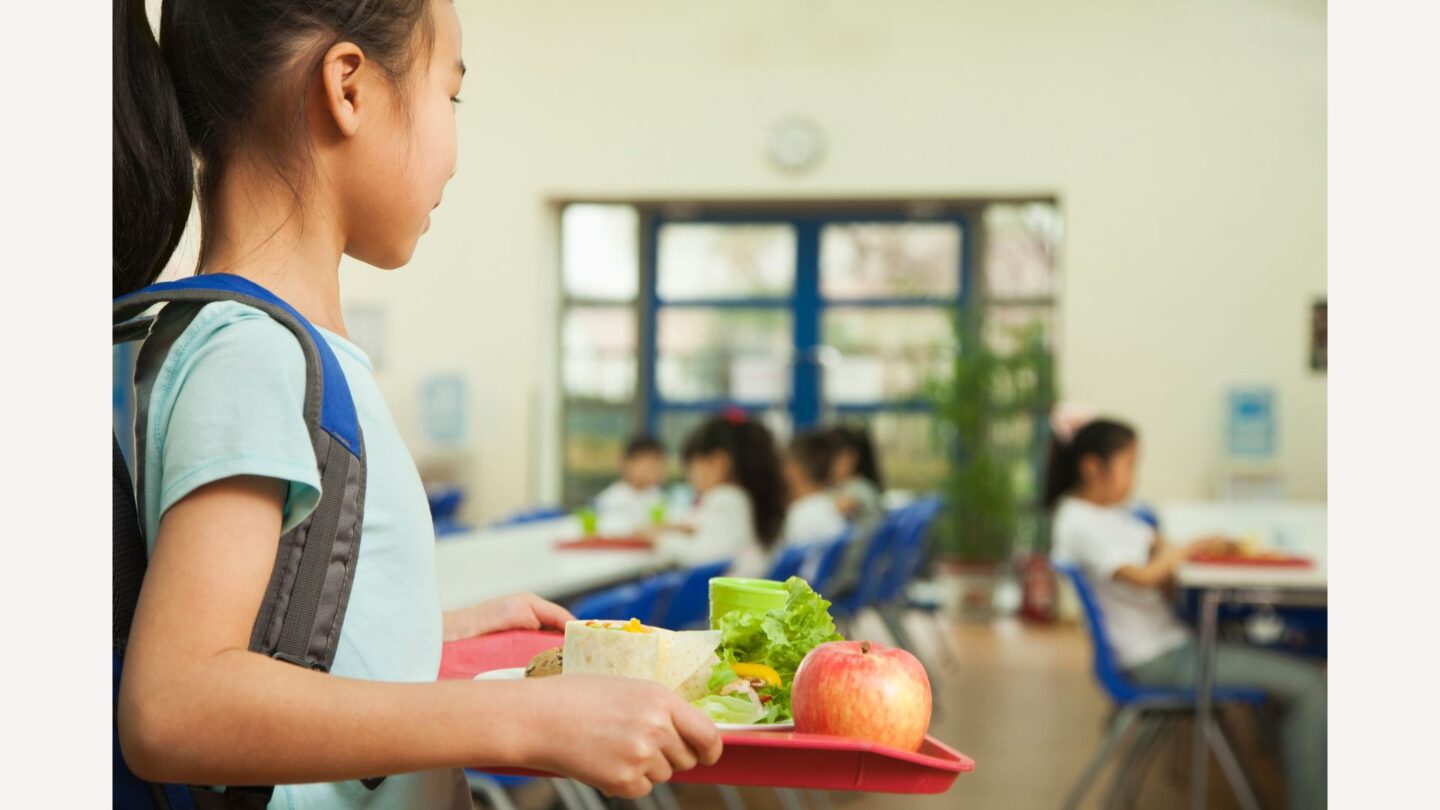 girl carrying school lunch tray-free school lunch