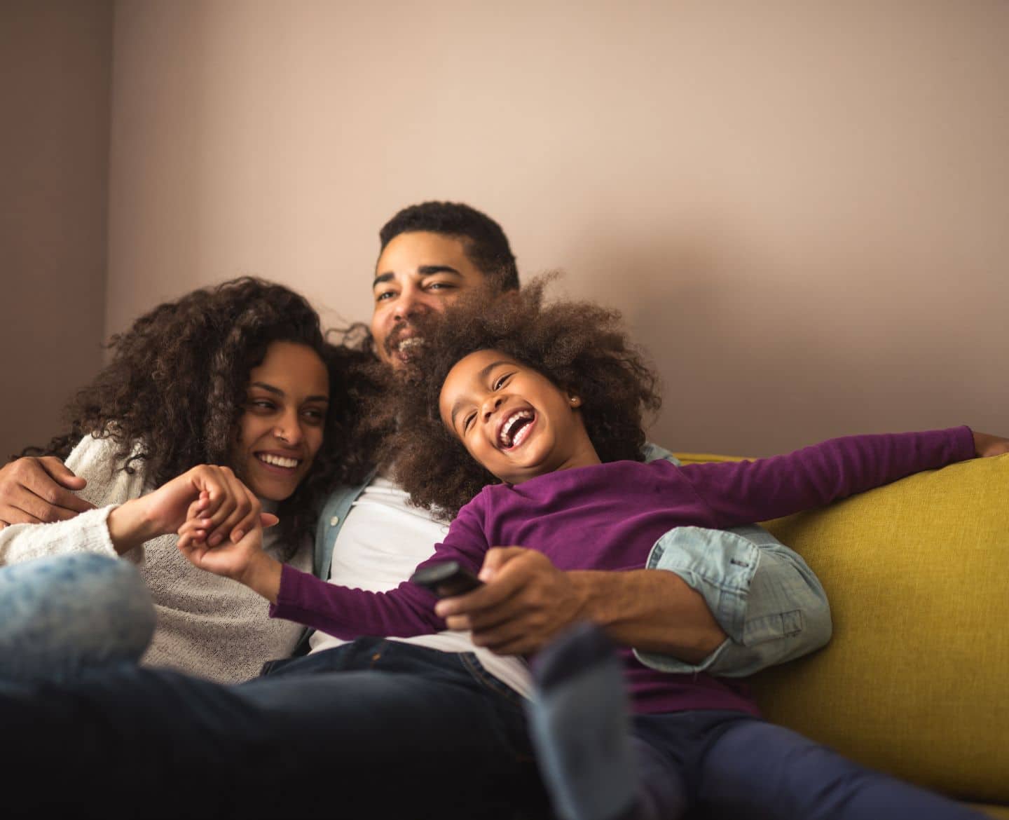 happy family sitting on the couch: lazy parenting fosters independence