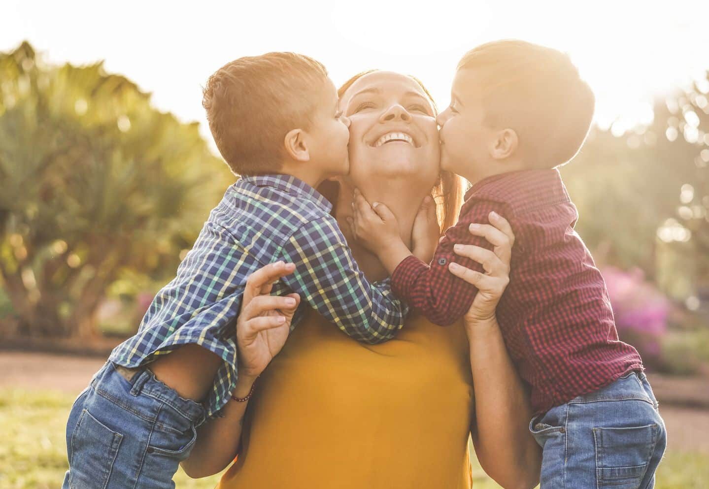 two boys kissing their mom: mom and son