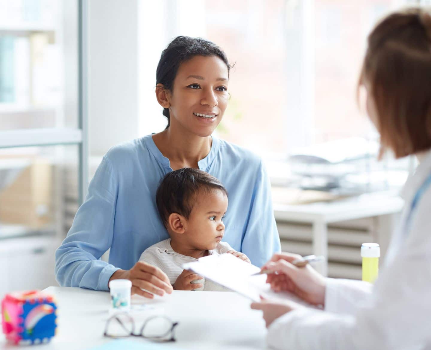 mother sits with baby at doctor - polio vaccine