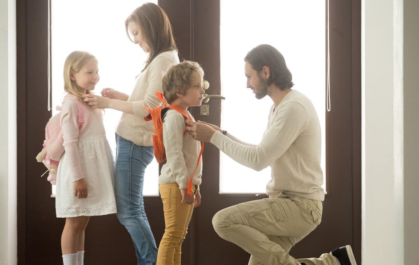 parents helping kids put their backpacks on