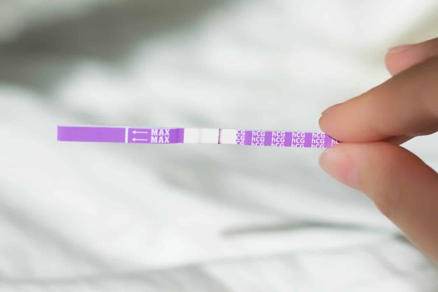 person holding a positive pregnancy test with faint line - pictures of faint line on pregnancy test