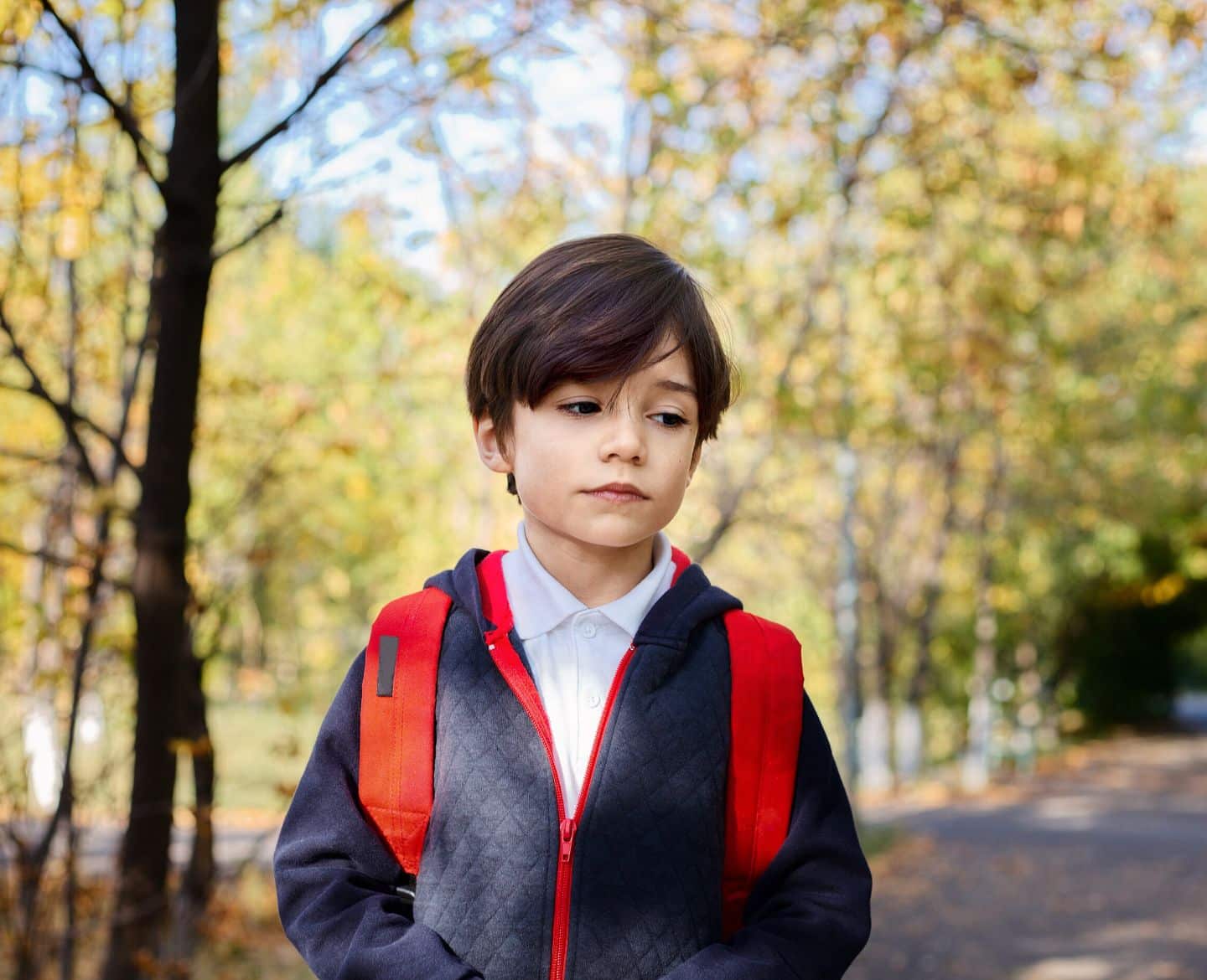 sad child walking to school with backpack - student stress