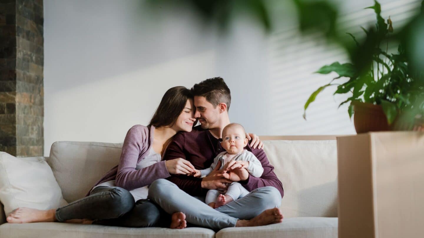 young happy family sitting on couch - news about student loan forgiveness