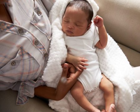 baby sleeping in mothers arms at home walking then sitting is one way how to get a baby to sleep Motherly