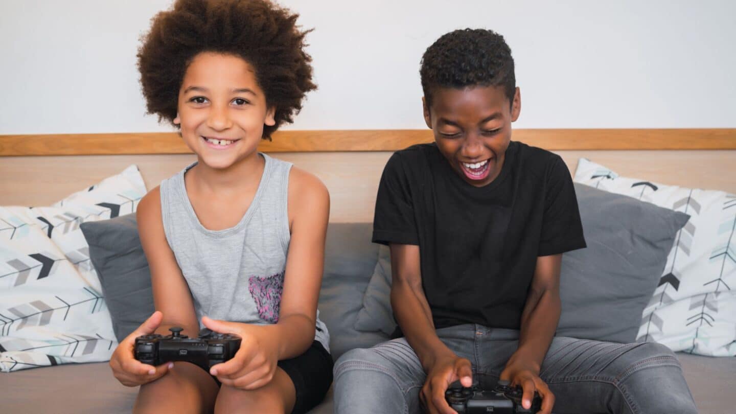 kids sitting on a couch playing video games