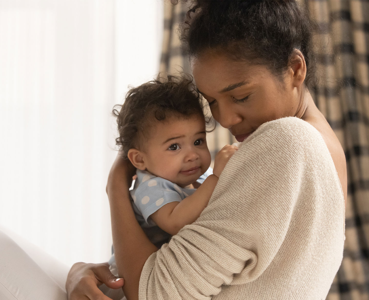 mom holding baby affected by social determinants