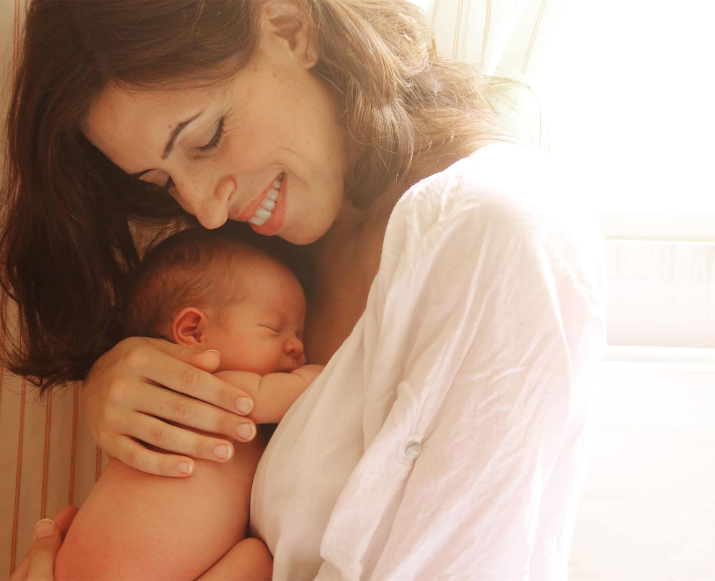 mom holding newborn baby taking paid family leave