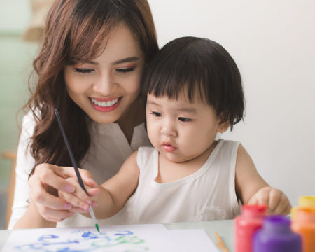 mom teaching her baby to paint