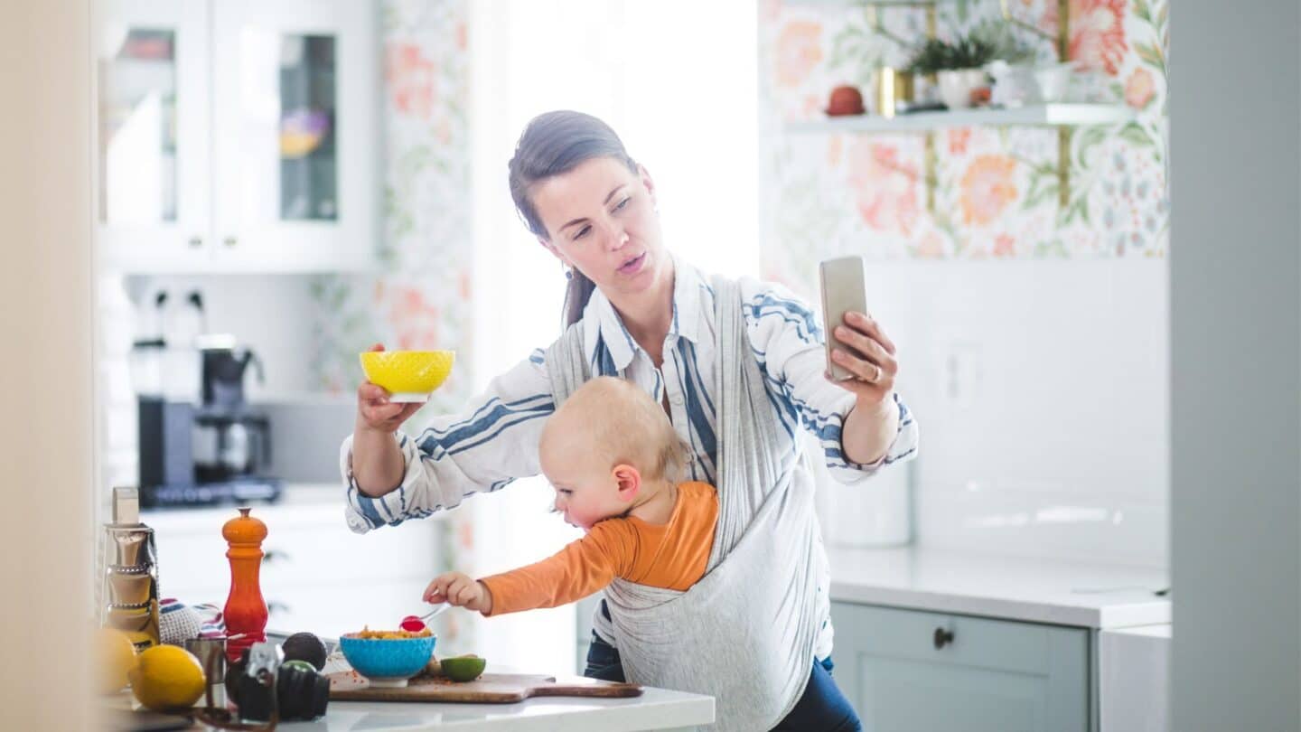 momfluencer filming in her kitchen while holding baby