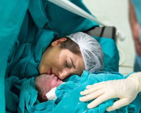 mother embracing newborn baby after c section birth