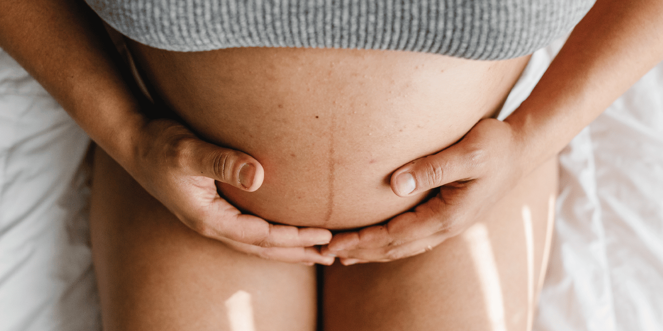 pregnant woman holding her bare belly - high blood pressure in pregnancy