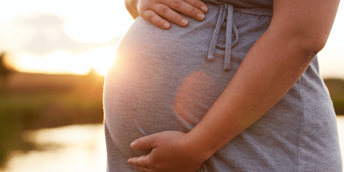 pregnant woman holding her belly in sunset - cdc says most pregnancy-related deaths are preventable