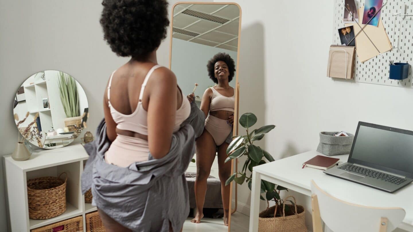 woman looking in mirror doing a mirror mantra