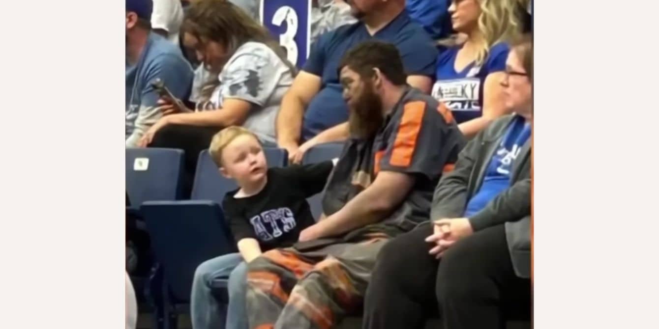 A coal miner dad sits with his son at a University of Kentucky basketball game.