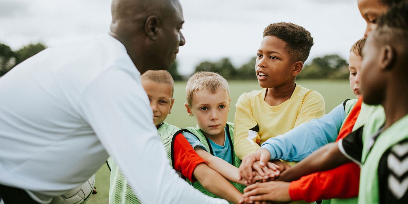 youth sports team huddling up, working against toxic sports culture