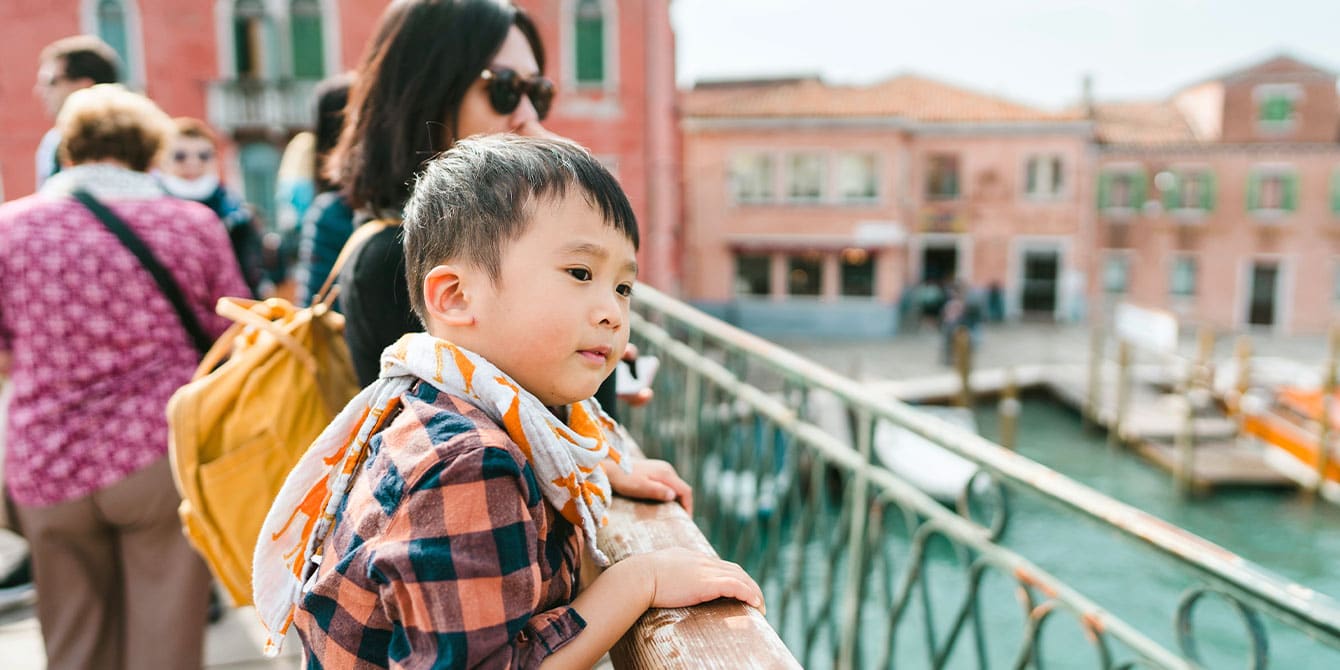 mom and kid on a bridge in venice italy, international travel with kids