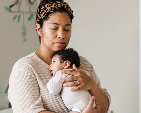 mom holding her newborn baby in a nursery