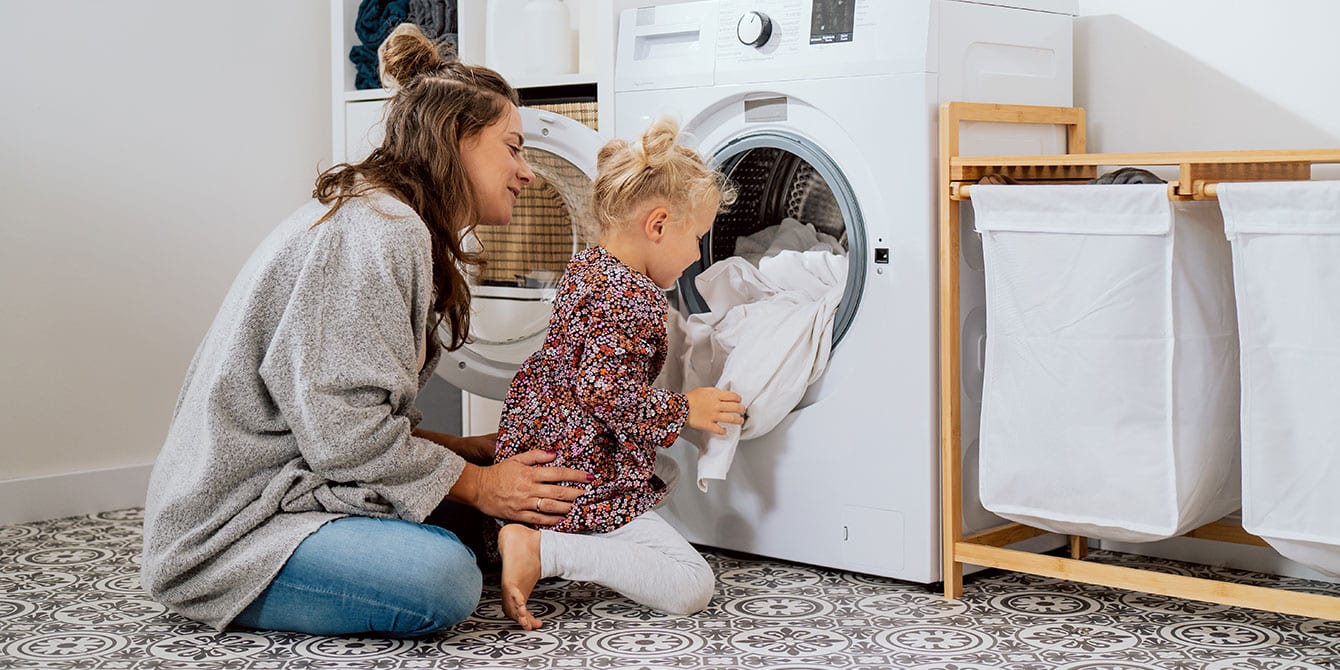 organized mom teaching kid to do laundry
