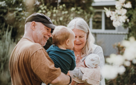 Grandaparents hugging their grandchild