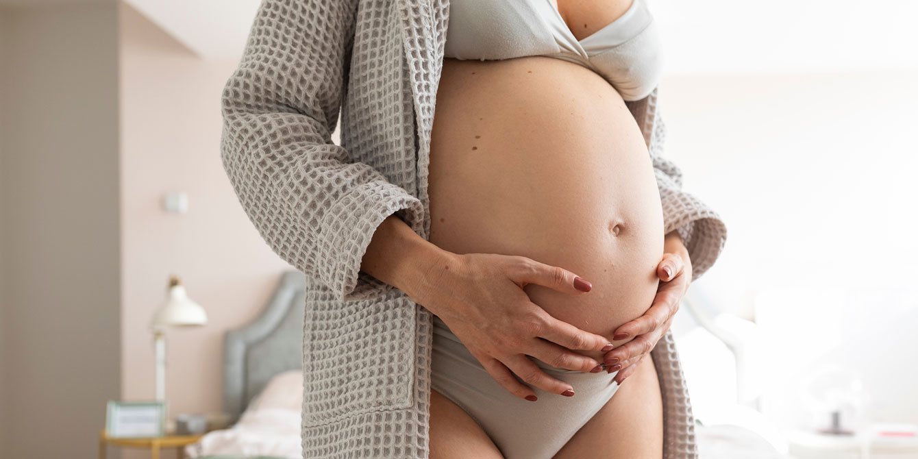 woman holding her pregnant belly wondering about bleeding during pregnancy