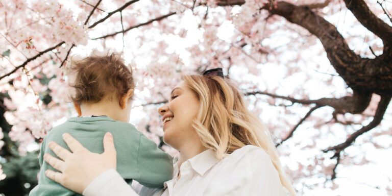 mom holding her child up to a tree - birth month trees